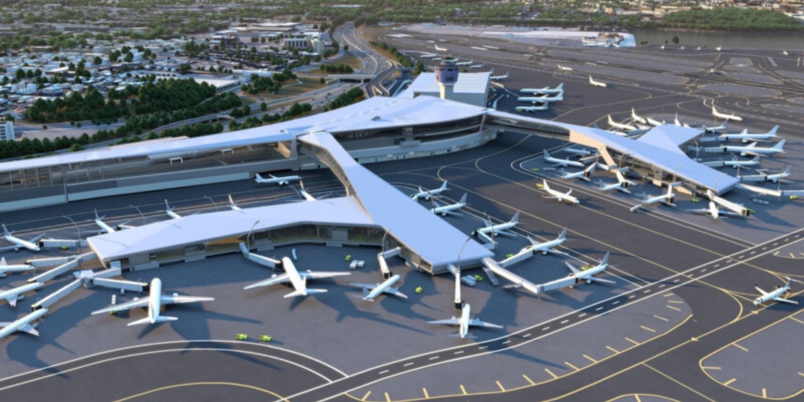 Panorama view of sprawling LaGuardia airport with many parked airplanes, runways, and taxiways, backed by wetlands and a distant city skyline.
