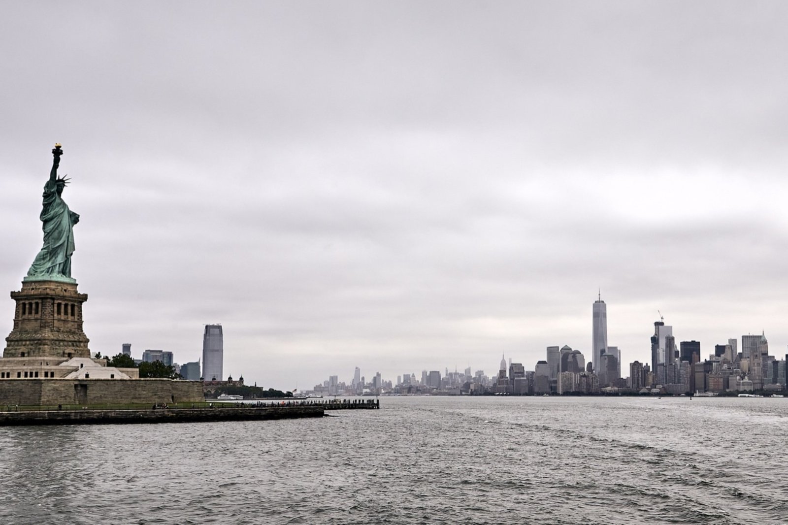 Staten Island beside the choppy Hudson River, with Manhattan’s skyline under overcast gray skies.