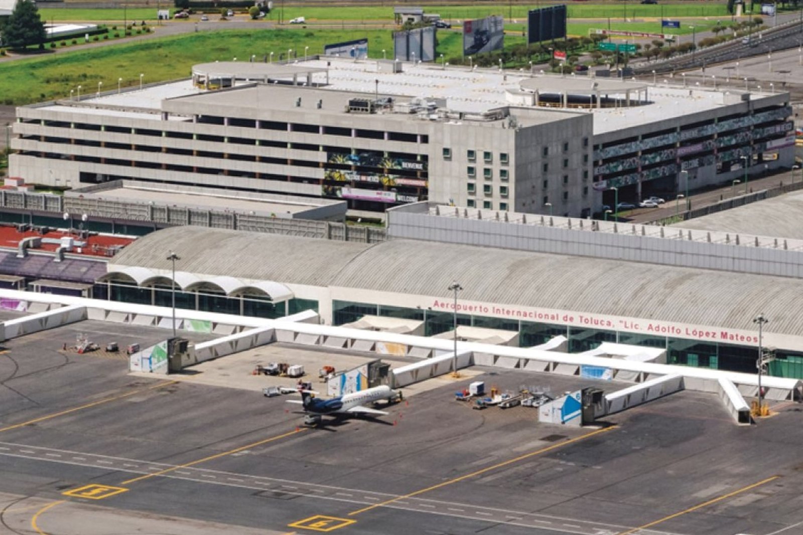 Aerial view of Teterboro airport terminal, with parked aircraft, gates, runway, and green fields.