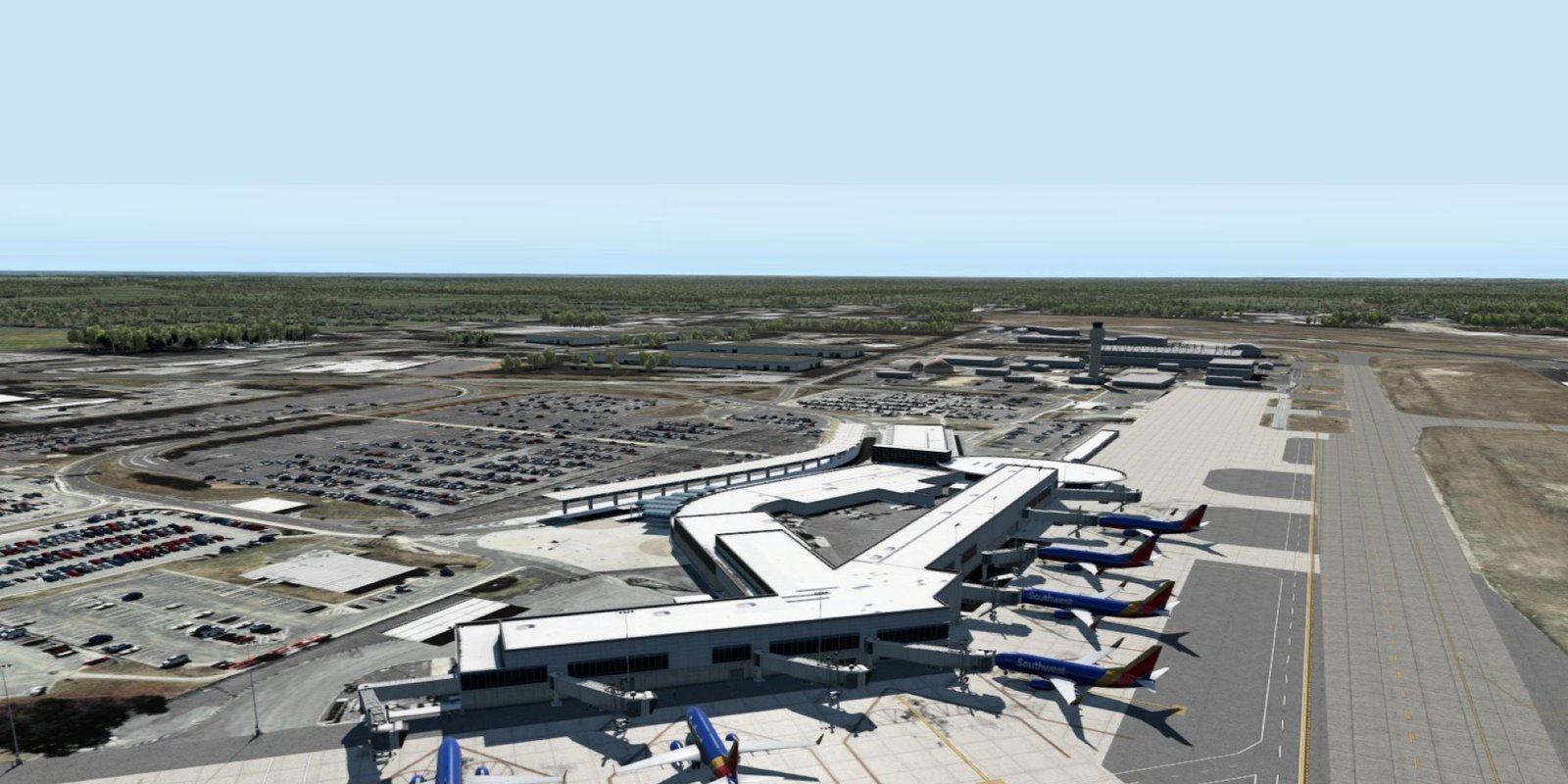 Panoramic aerial view of a modern airport terminal with multiple parked passenger jets, taxiways, runways, and cars under a clear blue sky.