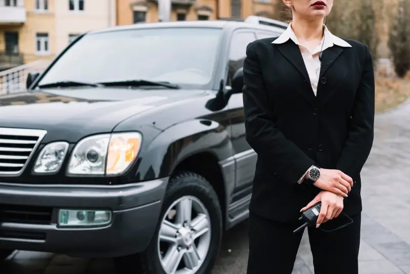 Chauffeur waiting beside a vehicle for diplomatic travel