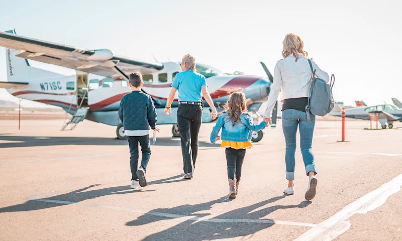 Family walking across an airport apron toward a small plane
